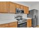 Modern kitchen features stainless steel appliances, and custom wood cabinetry at 9261 W Sheridan St, Phoenix, AZ 85037