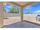 Covered patio overlooking gravel backyard with privacy walls and lush trees at 9261 W Sheridan St, Phoenix, AZ 85037