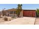 Charming home with desert landscaping and a wooden gated carport at 9347 E Edgewood Ave, Mesa, AZ 85208