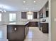 Spacious kitchen featuring dark cabinets, a large island, and tiled flooring at 9437 W Georgia Ave, Glendale, AZ 85305