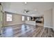 Open-concept living room with modern wood flooring, large windows, and a view into the kitchen at 9437 W Georgia Ave, Glendale, AZ 85305