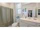 Clean bathroom features a toilet, sink, vanity, and shower with gray shower curtain at 9920 E Tamery Ave, Mesa, AZ 85212
