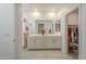 Bright bathroom featuring a double vanity, large mirror, and access to a walk-in closet at 9920 E Tamery Ave, Mesa, AZ 85212
