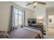Comfortable bedroom boasts neutral walls, a ceiling fan, and a window with sheer curtains at 9920 E Tamery Ave, Mesa, AZ 85212
