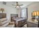 Cozy bedroom features a wooden bed frame, ceiling fan, and a window with natural light at 9920 E Tamery Ave, Mesa, AZ 85212