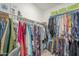 Walk-in closet showcasing ample hanging space with colorful clothing and organized storage solutions at 9920 E Tamery Ave, Mesa, AZ 85212