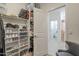 Organized walk-in closet with shelving for shoes and bags leading to bathroom at 9920 E Tamery Ave, Mesa, AZ 85212