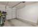 Clean garage with overhead door, concrete floor, and space for two vehicles with storage at 9920 E Tamery Ave, Mesa, AZ 85212