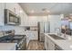 Open kitchen with stainless steel appliances, gas range, and quartz countertops with island seating at 9920 E Tamery Ave, Mesa, AZ 85212