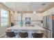 Modern kitchen with white cabinets, stainless appliances, quartz counters, and breakfast bar seating at 9920 E Tamery Ave, Mesa, AZ 85212