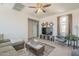 Well-lit living room featuring contemporary decor, modern ceiling fan, TV, comfortable seating, and neutral colors at 9920 E Tamery Ave, Mesa, AZ 85212
