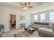 Upstairs living room features a sofa, ceiling fan, three windows with neighborhood views, and adjacent office space at 9920 E Tamery Ave, Mesa, AZ 85212