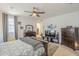 Large main bedroom includes a queen-sized bed, TV, modern ceiling fan, and view to a spacious walk-in closet at 9920 E Tamery Ave, Mesa, AZ 85212