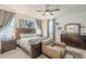 Well-lit main bedroom boasts neutral tones, a ceiling fan, and tasteful decor throughout the space at 9920 E Tamery Ave, Mesa, AZ 85212