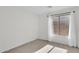 Bright bedroom with carpeted floors and a window dressed with flowing white curtains at 10304 E Plata Ave, Mesa, AZ 85212