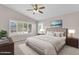 Serene bedroom boasts ample natural light from windows and a ceiling fan for comfort at 10304 E Plata Ave, Mesa, AZ 85212