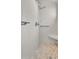 Modern shower features neutral tile, updated fixtures, a built-in seat, and a decorative pebble floor at 10304 E Plata Ave, Mesa, AZ 85212