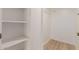 Bright walk-in closet with white shelving, white walls, and light wood flooring at 10330 W Thunderbird Blvd # C109, Sun City, AZ 85351