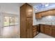Kitchen adjacent to the living room, boasting wooden cabinetry and light-filled space at 10330 W Thunderbird Blvd # C109, Sun City, AZ 85351