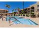 Community pool and spa area with ample seating, umbrellas, and palm trees at 10330 W Thunderbird Blvd # C109, Sun City, AZ 85351