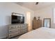Bedroom with a dresser and a TV with light colored wood flooring at 1055 W Diamondback Dr, Chandler, AZ 85286