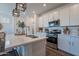 Modern kitchen island with stainless steel appliances, white cabinets and quartz countertop at 1055 W Diamondback Dr, Chandler, AZ 85286