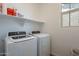 Convenient laundry room featuring a modern washer and dryer, plus ample storage shelf at 1055 W Diamondback Dr, Chandler, AZ 85286