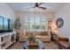 Comfortable living room boasts a ceiling fan and a large window with plantation shutters at 1055 W Diamondback Dr, Chandler, AZ 85286