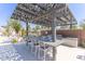 Outdoor kitchen featuring dining table with bar seating, stainless grills and decorative pergola at 1055 W Diamondback Dr, Chandler, AZ 85286