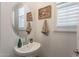 Stylish powder room features a pedestal sink, decorative mirror, and modern fixtures at 1055 W Diamondback Dr, Chandler, AZ 85286