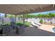 Covered patio with lounge chairs overlooking a well-manicured backyard with a grassy area at 11446 N 109Th St, Scottsdale, AZ 85259