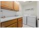 Well-organized laundry room with white washer and dryer, counter space and lots of cabinets at 1341 E Bellerive Dr, Chandler, AZ 85249