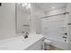 Clean bathroom with a white vanity, black hardware, a large mirror and tub with shower at 13465 N 158Th Ave, Surprise, AZ 85379