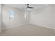 Empty bedroom features a ceiling fan, carpeted floors, and natural light from two windows at 13465 N 158Th Ave, Surprise, AZ 85379