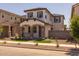 Charming two-story home featuring a cozy front porch with stone accents and a well-manicured front yard at 13465 N 158Th Ave, Surprise, AZ 85379
