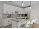 Kitchen featuring white cabinets, granite countertops, stainless steel appliances, gray backsplash, island sink, and chairs at 13465 N 158Th Ave, Surprise, AZ 85379