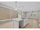Kitchen with white cabinets, granite countertops, island sink, and sliding glass doors to the patio at 13465 N 158Th Ave, Surprise, AZ 85379