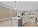 Kitchen with white cabinets, granite countertops, island sink, sliding glass doors, and a dining and living area view at 13465 N 158Th Ave, Surprise, AZ 85379