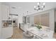 Open-concept kitchen featuring white cabinets, granite countertops, a kitchen island, adjacent dining area, and stainless appliances at 13465 N 158Th Ave, Surprise, AZ 85379