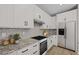 Well-lit kitchen featuring white cabinets, granite countertops, stainless steel appliances, and a modern design at 13465 N 158Th Ave, Surprise, AZ 85379