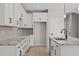 Spacious kitchen with white cabinets, granite countertops, gray backsplash, stainless steel appliances, and dark hardware at 13465 N 158Th Ave, Surprise, AZ 85379