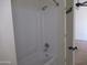 Bathroom tub and shower combination with white surround. View into carpeted room at 1450 E Laurel Ave, Gilbert, AZ 85234