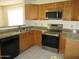 Well-equipped kitchen with stainless steel appliances, granite countertops, and wooden cabinetry at 1450 E Laurel Ave, Gilbert, AZ 85234