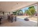 Covered back patio with dining table overlooks spacious backyard with fire pit at 14622 N 45Th Pl, Phoenix, AZ 85032