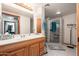 Bathroom featuring a vanity with double sinks, a glass block shower and tiled floor at 14622 N 45Th Pl, Phoenix, AZ 85032