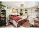 A cozy bedroom with wood floors, green walls, and a large bed with a red plaid blanket at 14622 N 45Th Pl, Phoenix, AZ 85032