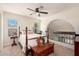 Cozy bedroom featuring a four-poster bed, arched nook, and a window with natural light at 14622 N 45Th Pl, Phoenix, AZ 85032