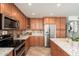 This kitchen features wood cabinets, stainless steel appliances and granite countertops with backsplash at 14622 N 45Th Pl, Phoenix, AZ 85032