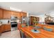 Kitchen with stainless steel appliances, wood cabinetry, and view of the living room at 14622 N 45Th Pl, Phoenix, AZ 85032