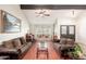 Bright living room featuring hardwood floors, a piano, large windows, and comfortable seating at 14622 N 45Th Pl, Phoenix, AZ 85032